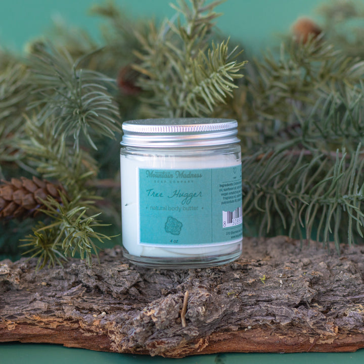 Tree Hugger Body Butter, a handcrafted body butter. Woodsy scent with cedarwood, pine, and shea butter in a glass jar.